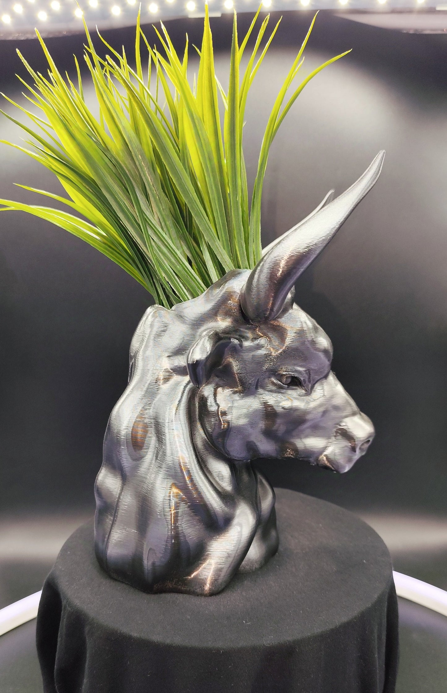 Hand-painted metallic bull head planter with gold accents, designed for holding succulents, displayed on a dark wooden surface