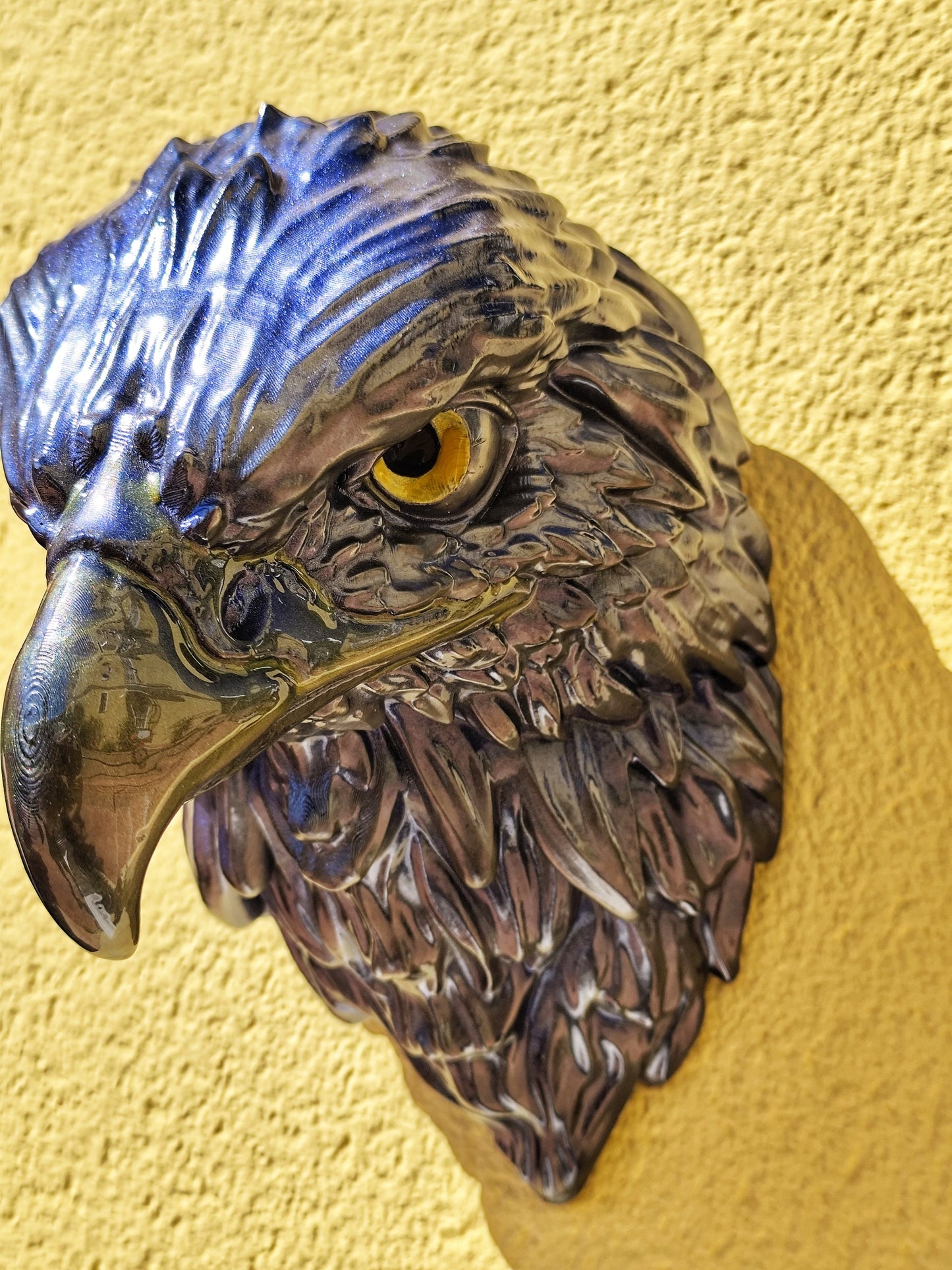 Shiny blue eagle head sculpture with intricate details